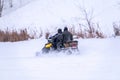 Two man on a snowmobile riding on the snow surface in the winter forest Royalty Free Stock Photo