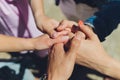 Two man and three women holding hands on a table implying a polyamory relationship or love triangle. Royalty Free Stock Photo