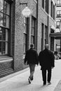 Two man walking in street in downtown Vancouver. Two businessmen in suits walking outdoor in urban city.