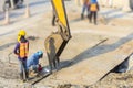 Two man workers or technical wear safety suits during welding steel plate on ground or road and during press by use stick bucket Royalty Free Stock Photo