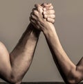 Two man& x27;s hands clasped arm wrestling, strong and weak, unequal match. Arm wrestling thin hand and a big strong arm Royalty Free Stock Photo