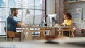 Two Managers Sitting Behind Desks Next to Big Window with City View and Work with Analytical Reports