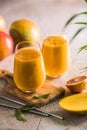 Two mango lassi or kesar milk in glasses. Indian healthy ayurvedic cold drink with mango. Freshness lassi made of yogurt, water,