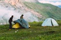 Two Mans adventurer pitching tent camping gear outdoor cloudy Travel survival lifestyle concept summer trip vacations in mountains