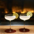 Two margarita cocktails with tequila and Cointreau at wooden bar counter decorated with lime slices and salt Royalty Free Stock Photo