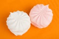 Two marshmallows on orange tablecloth Royalty Free Stock Photo