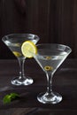 Two Martini glasses with cocktail and olives on black background. Royalty Free Stock Photo