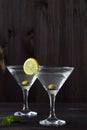 Two Martini glasses with cocktail and olives on black background. Royalty Free Stock Photo