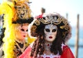 Two masked people with big wigs dressed up for fun at Venice carnival Italy Royalty Free Stock Photo