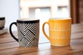 two matching designer coffee mugs on a table Royalty Free Stock Photo