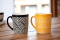 two matching designer coffee mugs on a table