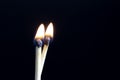 Two matchsticks burning side by side, black background. close-up. Royalty Free Stock Photo