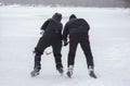 Two mature amateur men fighting while laying hockey on a frozen river Dnipro in Ukraine