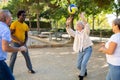 Two mature couples playing volleyball in summer park