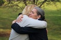 Two mature friends hugging