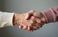 Two mature hands shake in gesture of gentle connection, support. Image care, empathy, partnership between elderly individuals. Royalty Free Stock Photo