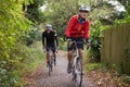 Two Mature Male Cyclists Riding Bikes Along Path Royalty Free Stock Photo