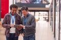 Two Mature Male Students Or Teachers With Digital Tablet Walk Through Hall Of College Building Royalty Free Stock Photo