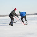 Two mature man fighting for the pack while playing hockey on a frozen river Dnepr in Ukraine