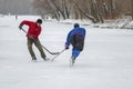 Two mature men fighting for the puck while playing hokey on a frozen river Dnipro in Ukraine
