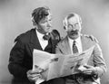 Two mature men reading a newspaper together Royalty Free Stock Photo