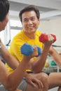 Two mature men smiling and lifting weights in the gym Royalty Free Stock Photo