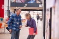 Two Mature Students Or Teachers Walking Through Communal Hall Of Busy College Campus Building Royalty Free Stock Photo