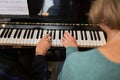Two mature women at home play the piano together and singing. Hobby, vocal and musicianship, piano lessons for adults.