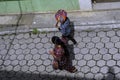 Two Mayan women are eating fruit and walking down a street in Zunil Guatemala.
