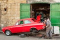 Two mechanics repair old vintage red car