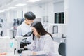 Two medical scientist working in Medical laboratory , young female scientist looking at microscope. Royalty Free Stock Photo