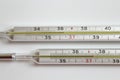 Two medical thermometers to measure the tempetature, one of them with a tempetature .