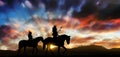 Two members of the Assiniboine tribe on horseback at sunset Royalty Free Stock Photo