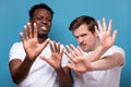 Two men african american and caucasian making stop sign making a social distance gesture