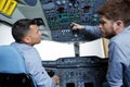 Two men in aircraft cockpit apprentice asking question Royalty Free Stock Photo