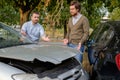 Two men arguing after a car accident on the road Royalty Free Stock Photo