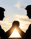 Two men arm wrestling. Rivalry, vs, challenge, strength comparison. Sunset, sunrise. Silhouette of hands that compete in Royalty Free Stock Photo