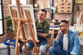 Two men artists drawing with relaxed expression at art studio