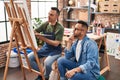 Two men artists drawing with relaxed expression at art studio