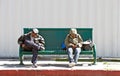 Two men asleep mid-day while waiting for the city bus to arrive in Wilmington, California USA Royalty Free Stock Photo
