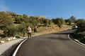 two men with backpacks, backpackers walking along road with magnificent natural scenery, hiking, trekking olive groves, watching