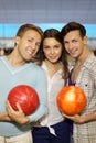 Two men with balls and girl in bowling club Royalty Free Stock Photo