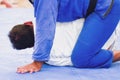 Two unidentifiable men practicing Brazilian Jiu-Jitsu on a blue mat Royalty Free Stock Photo