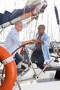 Two men in blue shirts sitting on sailing yacht in the port