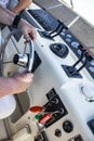 Two men on a boat, with hands and arms showing - one man drives and operates at cockpit and the other is relaxing and watching - u