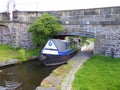 Two men on boat passing under bridge