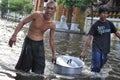 Two men are bringing free food for the refugees in a flooded street of Bangkok, Thailand, on 31 October 2011