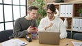 Two men business partners using laptop and smartphone working at office Royalty Free Stock Photo