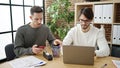 Two men business partners using laptop and smartphone working at office Royalty Free Stock Photo