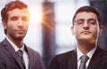 Two serious young businessmen standing with arms crossed in office Royalty Free Stock Photo